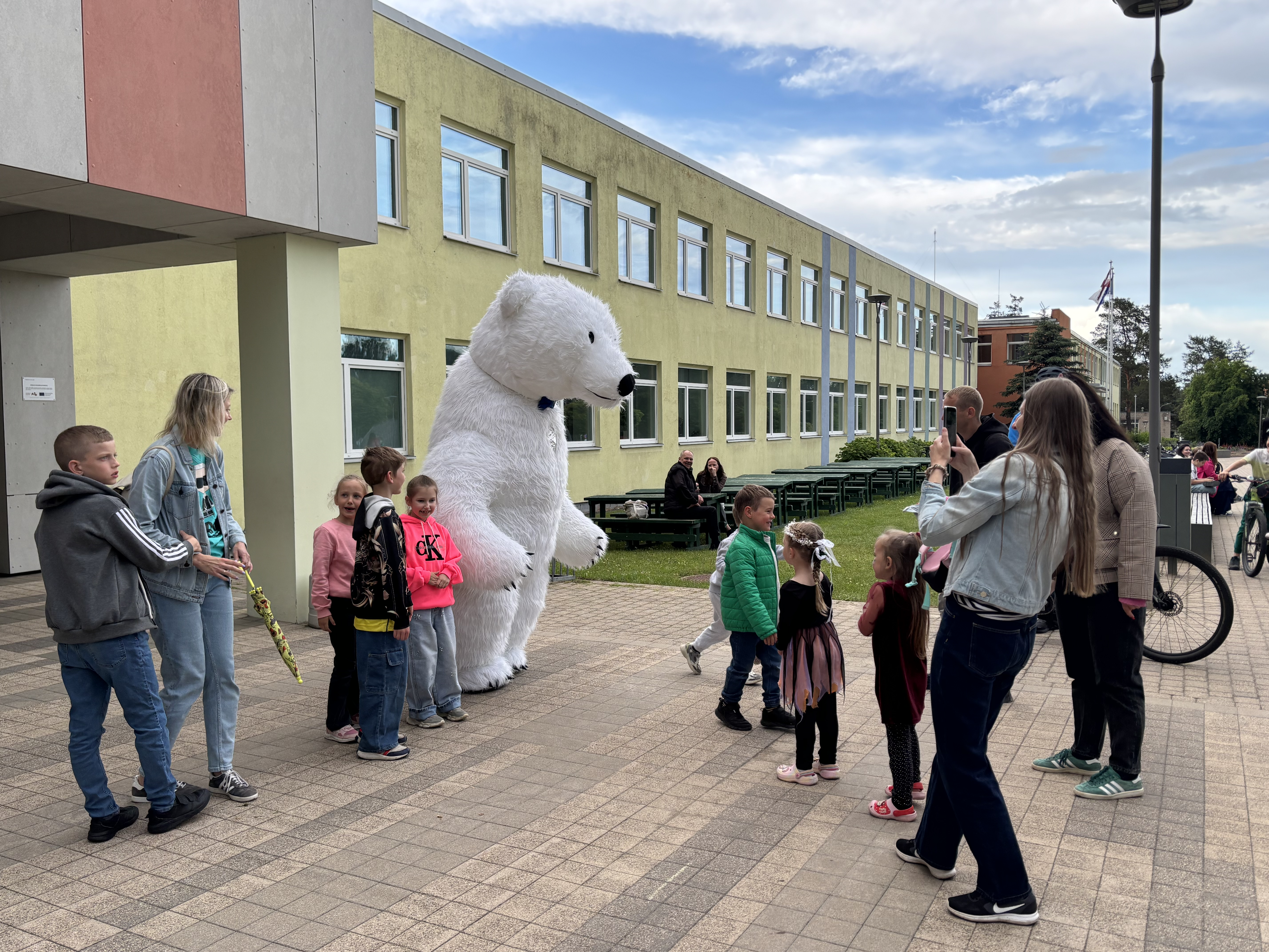 Polārlācis pasniedz dāvanu un balonus jubilejā